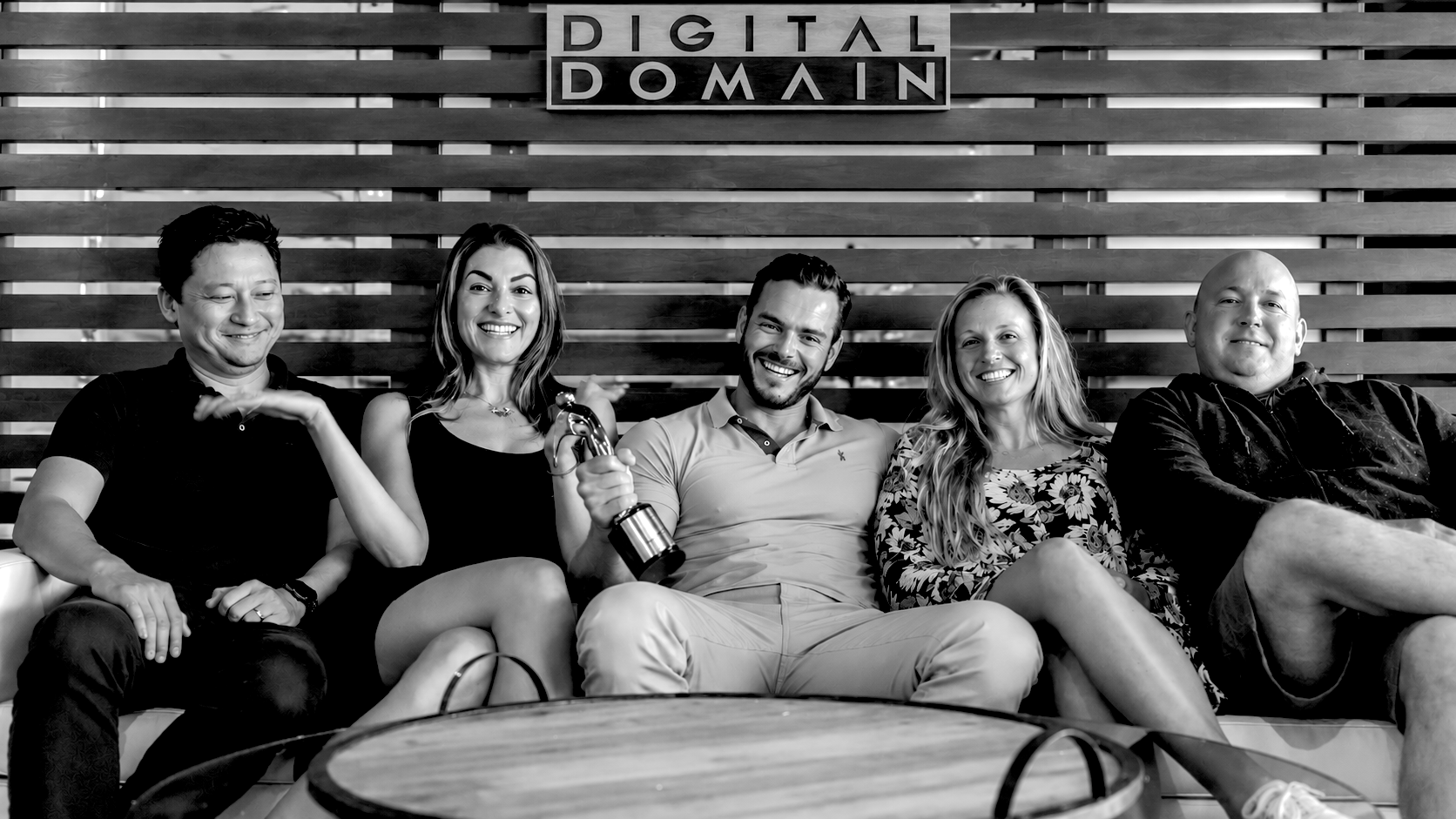 Pierre celebrating with colleagues beneath the Digital Domain sign