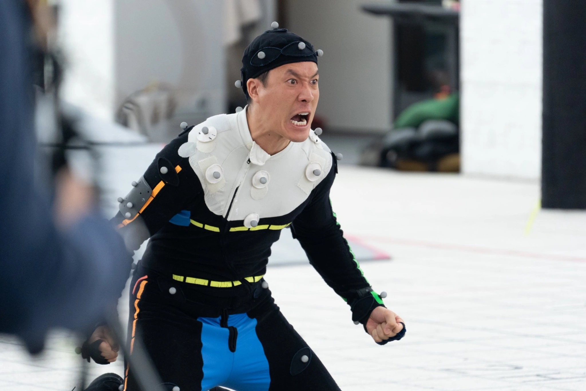 A motion-capture performer acting on a bright studio stage
