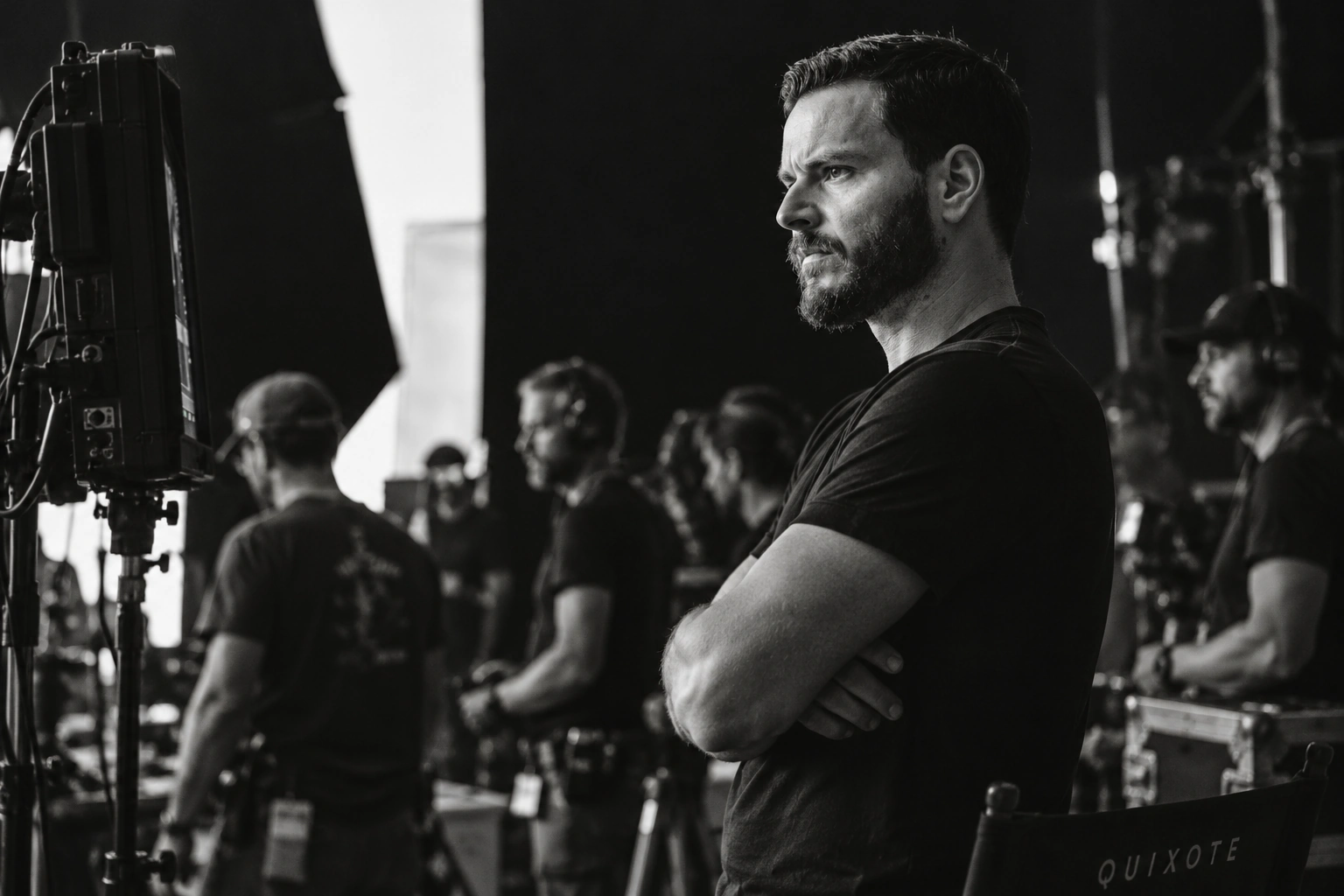 A black-and-white portrait of a director beside production equipment