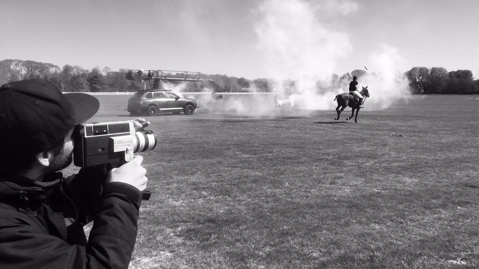 A camera crew filming a rider on horseback in an open field